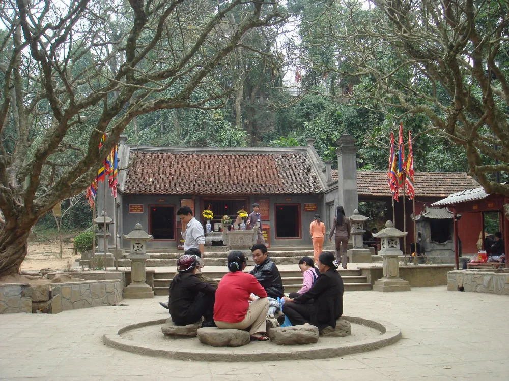 Sân đền Trung với nhà đền, mọi người ngồi quanh bệ tròn